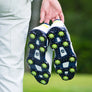 A golfer holding his shoes showing the underside attached slime green Pulsar Golf Spikes.
