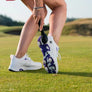A close-up of a person's foot wearing a white golf shoe with purple accents, holding a Prosoft brush on a grass golf course.