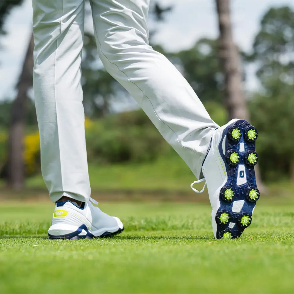 The underside of a golfers shoe showing the attached slime green Pulsar Golf Spikes. 
