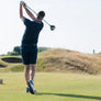 A golfer taking a swing on a golf course.