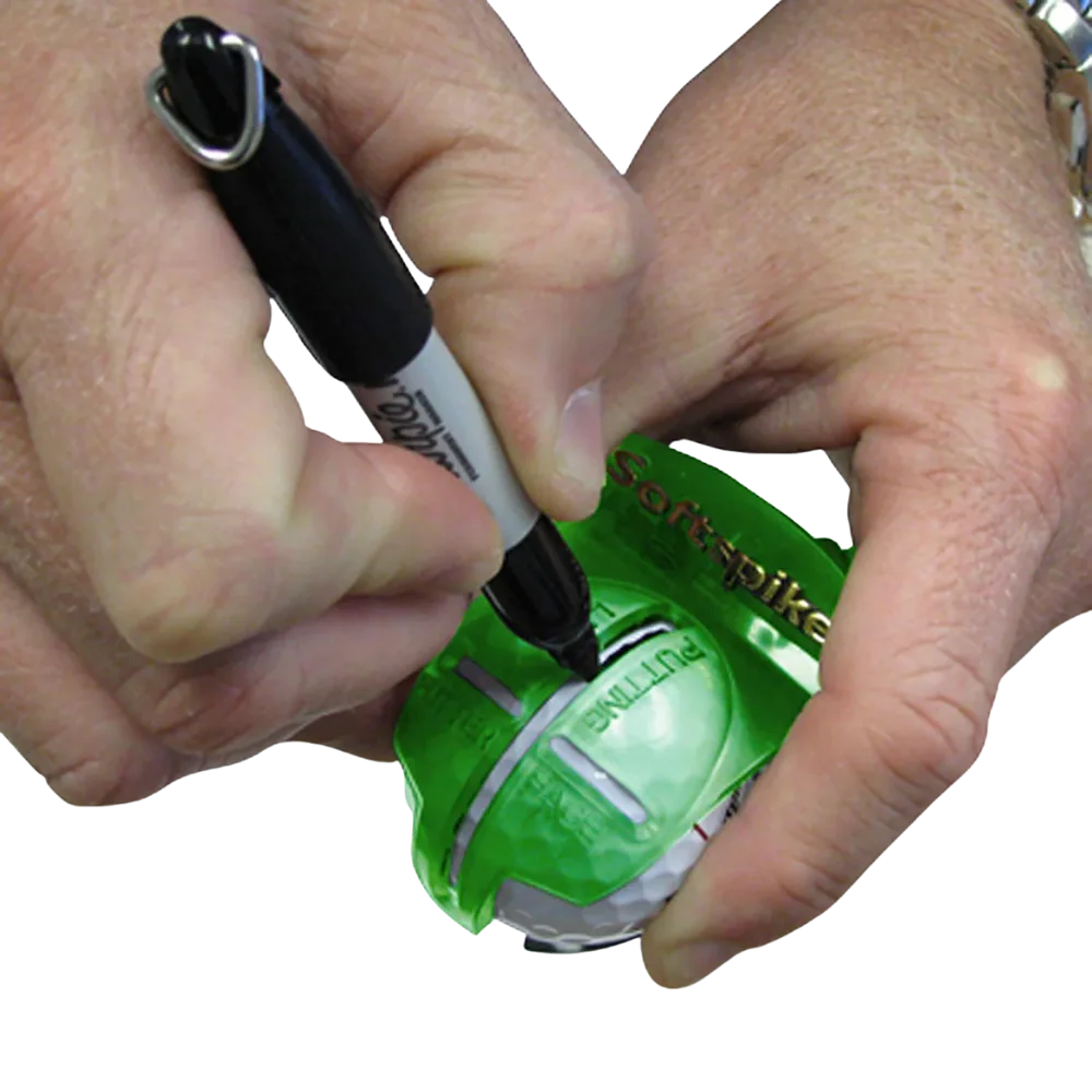 Person marking a golf ball with a marker with the help of an alignment tool on a white background