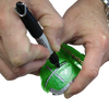 Person marking a golf ball with a marker with the help of an alignment tool on a white background